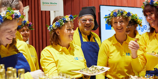 Personer om står i en monter och visar svensk mat.
