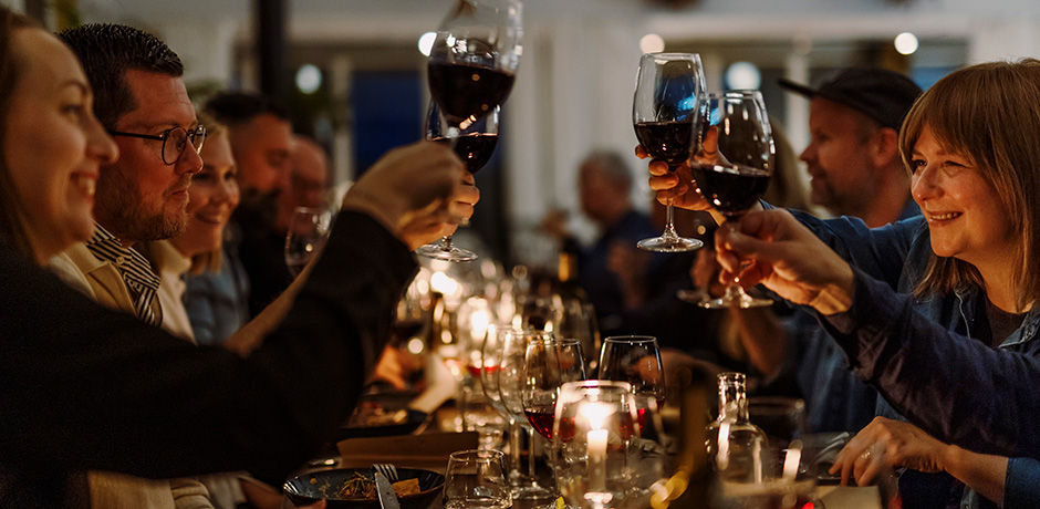 Restaurangbesökare sitter runt bord med levande ljus